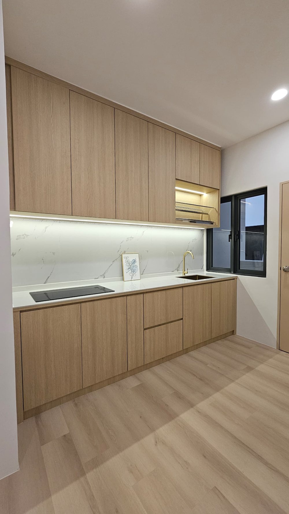 Fitted kitchen with wood-grain cabinets and marble-look backsplash